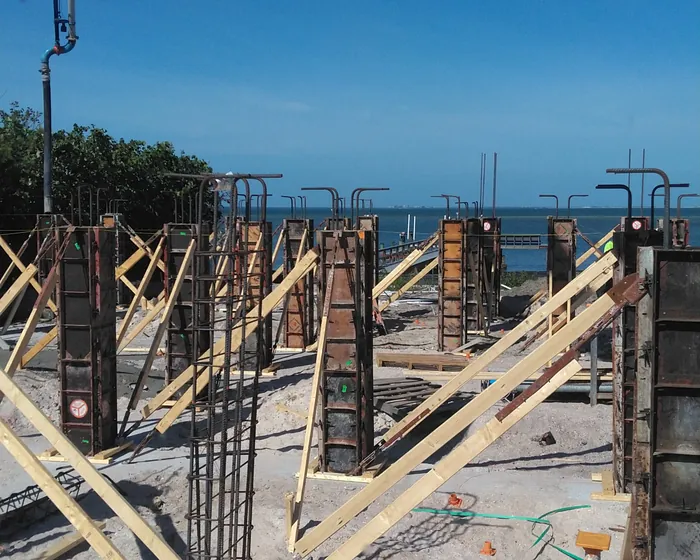 Braced column forms with rebar cages standing on a Gulf front building lot